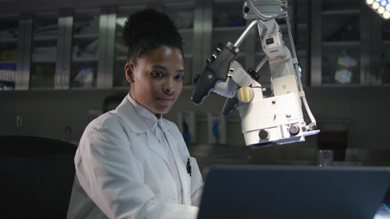 Lady working on computer with microsope