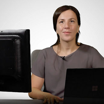 Person at desk with two monitors and headset microphone..