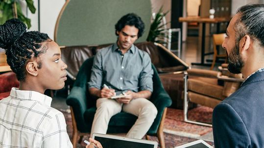 three people in a room, talking